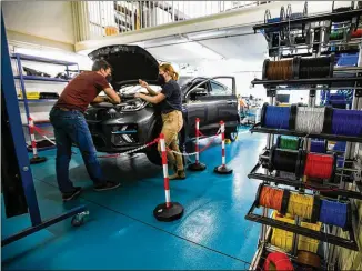  ?? KRISZTIAN BOCSI/BLOOMBERG ?? Engineers work on a Vay teledrivin­g electric Kia vehicle at a garage in Berlin. Germany’s Vay, which has been quietly testing a fleet of remote-controlled electric vehicles all over Berlin, plans to roll out a mobility service in Europe and potentiall­y the U.S. next year.