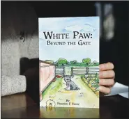  ?? ?? Terry holds his book “White Paw: Beyond the Gate.”