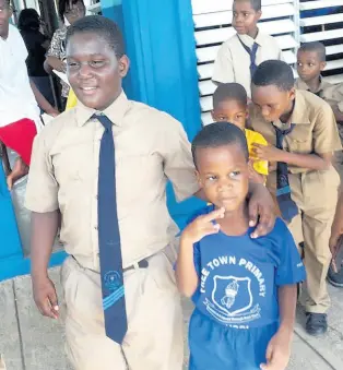  ?? CONTRIBUTE­D ?? A ‘big brother’ escorting his ‘little brother’ to class at Free Town Primary School.