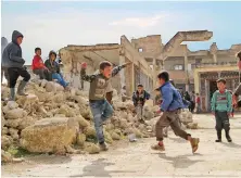  ?? Syrian children play in the yard of a war-damaged school in Idlib. ??