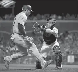  ?? Ezra Shaw Getty Images ?? YASIEL PUIG IS TAGGED out by San Francisco catcher Nick Hundley in the fourth inning as he tries to score on a grounder to short by Chris Taylor.