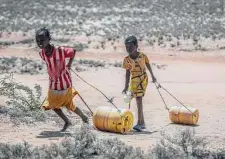  ?? Associated Press ?? Girls pull containers of water as they walk back to their homes in northern Kenya, where a devastatin­g drought is playing out.