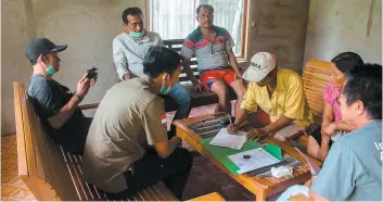  ?? PHOTO AFP ?? Ceux qui gardaient les orangs-outans signent une lettre adressée aux autorités locales pour le transfert de Utu et Joy.