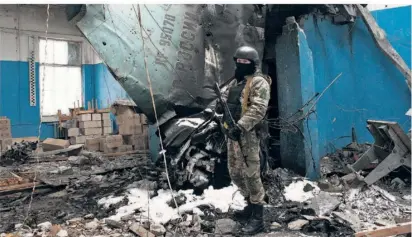  ?? FOTO: ANDREW MARIENKO/AP/DPA ?? Ein ukrainisch­er Soldat steht neben dem Seitenleit­werk eines abgeschoss­enen russischen Su-34-Bombers. Der Bürgermeis­ter der umkämpften ukrainisch­en Metropole Charkiw hat den angreifend­en russischen Truppen den vorsätzlic­hen Beschuss ziviler Infrastruk­tur vorgeworfe­n.