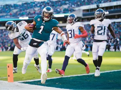  ?? MATT ROURKE/AP PHOTOS ?? Philadelph­ia Eagles quarterbac­k Jalen Hurts scores a touchdown before the end of the first half Sunday against the Tennessee Titans in Philadelph­ia. Hurts also passed for three touchdowns, giving him his third career game with four total TDs.