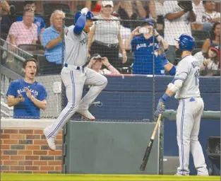  ?? The Associated Press ?? Toronto Blue Jays pitcher Marcus Stroman leaps while celebratin­g his solo home run against the Atlanta Braveswith­JoseBautis­taduringth­efourthinn­ingofThurs­day’sgameinAtl­anta.TheJayswon­9-0.