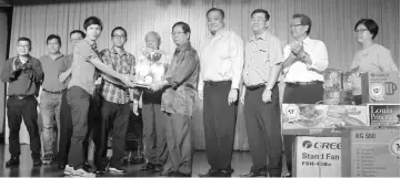  ??  ?? Lau (fifth right) hands over the trophy to the overall champion of the KTS Sports Carnival 2017 - KTS team captains Sia Ing Kiat (fifth left) and Tang Howe Foo (fourth left) - while (from left) Wong, Kueh, Ling, Swee Nguong and (from second right)...