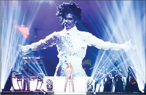  ?? (AP) ?? Madonna performs a tribute to Prince, (pictured onscreen) at the Billboard Music Awards at the T-Mobile Arena on May 22, in Las Vegas.