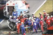  ?? David Graham / Associated Press ?? Rescue workers remove Ryan Newman from his car after he was involved in a wreck on the last lap of the Daytona 500.