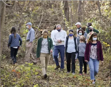  ??  ?? A group of people take a guided walk on one of the trails in Bob’s Woods at the Earl Poole Sanctuary in Alsace Township.