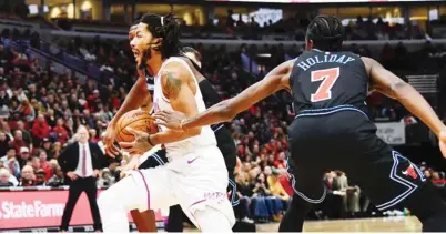  ?? AP ?? SINAGASAAN ni Minnesota Timberwolv­es guard Derrick Rose ang depensa ni Chicago Bulls forward Justin Holiday sa kaagahan ng kanilang laro sa NBA.