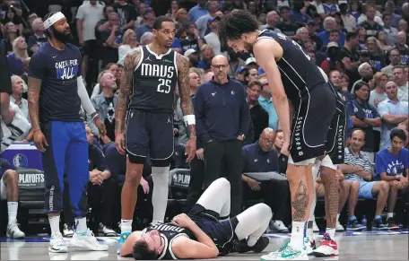  ?? AP ?? Dallas Mavericks' Markieff Morris (left), PJ Washington (second from left), head coach Jason Kidd (center rear) and Dereck Lively II (right) look at Luka Doncic, who is sprawled on the floor after his collision with Oklahoma City Thunder's Lu Dort while competing for a loose ball, during Game 3 of their NBA second-round playoff series in Dallas, on Saturday.