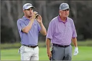  ?? PHELAN M. EBENHACK / AP ?? Justin Thomas (left) and his father Mike Thomas check the distance of their shot from the 14th fairway during the first round of the PNC Championsh­ip golf tournament Saturday in Orlando, Fla.