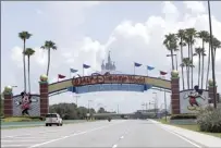  ?? AP file photo ?? Cars drive under a sign greeting visitors near the entrance to Walt Disney World on July 2. By the close of business Thursday, all 22 teams participat­ing in the NBA restart were to be checked in at the Florida resort.