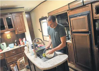  ?? Photos by RJ Sangosti, The Denver Post ?? Bailey Queen, 23, is an EMT and is staying in an RV parked in front of his parent’s Thornton home in order to isolate and protect his family from any potential exposure he faces on the job during the coronaviru­s pandemic.