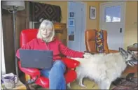  ?? (AP/Gillian Flaccus) ?? Crowley works on her laptop at her home with Mollie at her side in Hood River.