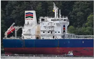  ?? AP/The Canadian Press/JONATHAN HAYWARD ?? An oil tanker dwarfs an accompanyi­ng security vessel Tuesday at Kinder Morgan Inc.’s Trans-Mountain pipeline terminal in Burnaby, British Columbia.