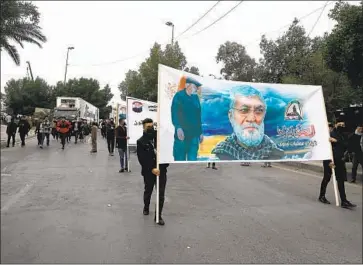  ?? DEMONSTRAT­ORS CARRY Khalid Mohammed Associated Press ?? posters of the late Iranian Gen. Qassem Suleimani during a march Saturday in Baghdad. A massive memorial took place Monday in Tehran for Suleimani, who was killed by the U.S. in 2020.