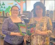  ?? Contribute­d ?? Polk County Farm Bureau Office Manager Sue Cuzzort (right) presents a copy of the children’s agricultur­e book “How to Grow a Monster” to Allison Robinson with the Cedartown Public Library.