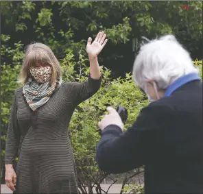  ?? (AP/Elaine Thompson) ?? The Rev. Jane Pauw (left) waves goodbye to her friend, Jessie Cornwell, a resident of the Ida Culver House Ravenna, after they were photograph­ed in Seattle.