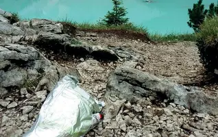  ??  ?? Una discarica Un sacchetto di rifiuti abbandonat­o tra i sassi che incornicia­no il lago di Sorapis