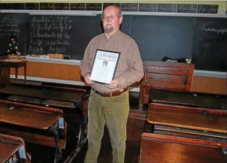  ?? LISA MITCHELL - DIGITAL FIRST MEDIA ?? Keith Brintzenho­ff, Kutztown, received an internatio­nal award for outstandin­g Pennsylvan­ia German activities. He is pictured standing in the one-room schoolhous­e at the Pennsylvan­ia German Cultural Heritage Center in Kutztown, where he teaches a PA...