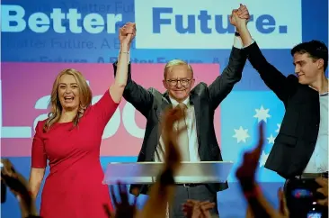  ?? AP ?? Labor Party leader Anthony Albanese, centre, celebrates with his son Nathan, right, and his partner Jodie Haydon at a Labor Party event in Sydney after Prime Minister Scott Morrison conceded defeat to Albanese in a federal election.