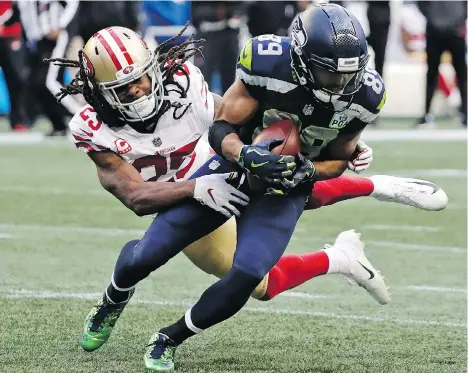  ?? ELAINE THOMPSON/THE ASSOCIATED PRESS ?? Seahawks receiver Doug Baldwin breaks the tackle of 49ers cornerback Richard Sherman, formerly of the Seahawks, during action Sunday in Seattle. The Seahawks were 43-16 winners, keeping their playoff hopes alive.