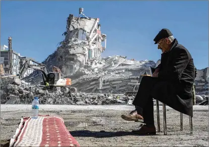  ?? PETROS GIANNAKOUR­IS/ASSOCIATED PRESS ?? Mehmet Nasir Duran, 67, watches heavy machinery remove debris from a building where five of his family members are believed to be trapped in Nurdagi, Turkey. Thousands who lost their homes in a catastroph­ic earthquake that devastated parts of Turkey and Syria remain huddled around campfires, clamoring for food and water in the bitter cold.