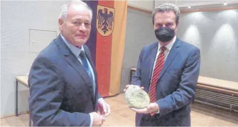  ?? FOTO: JOSEF SCHNEIDER ?? Gerhard Ziegelbaue­r (links) hat dem CDU-Politiker Günther Oettinger für seinen Vortrag im Olgasaal der Reinhardt-Kaserne mit einem Ammoniten gedankt.