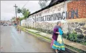  ?? REUTERS ?? A woman walks past a graffiti reading ‘No political parties, Yes to selfdeterm­ination’ in the Purepecha town .