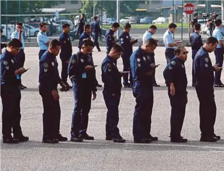  ?? PIC BY MOHAMAD SHAHRIL BADRI SAALI ?? Royal Malaysian Air Force personnel waiting to cast their votes in the Seri Setia by-election at Ababil Multipurpo­se Hall in the Subang Airbase, Subang, yesterday.