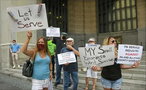  ?? Steve Mellon/Post-Gazette ?? Margarita Pignarelli, left, a Neville Island resident and an employee of Grill 565 in Bellevue, joins about 40 others in protesting Allegheny County’s ban on alcohol at bars and restaurant­s on July 2 at the City-County Building in Downtown.