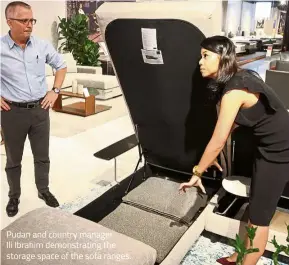  ??  ?? Pudan and country manager
Ili Ibrahim demonstrat­ing the storage space of the sofa ranges.