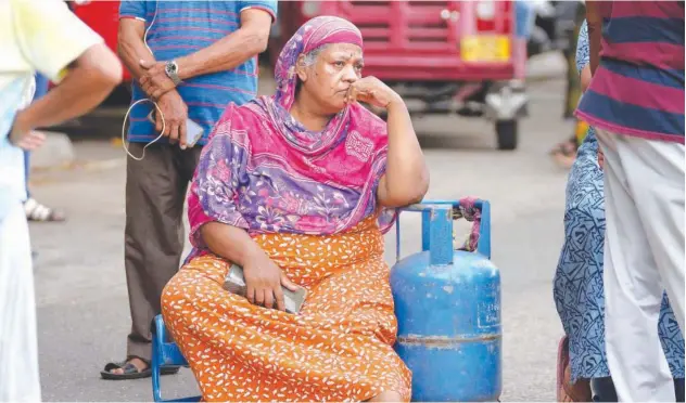  ?? Associated Press ?? ↑
An elderly woman sits outside a police station during a protest demanding cooking gas in Colombo on Saturday.