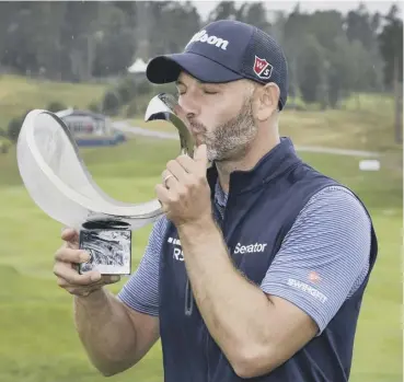  ??  ?? 0 Paul Waring of England kisses the trophy after winning the Nordea Masters at Hills Golf Club.