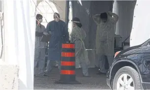  ?? ROSIE DIMANNO TORONTO STAR ?? Dr. Kashif Irshad gowns up in the off-site assessment tent at William Osler Health System complex. This drive-through stand-alone facility is about half-mile from Etobicoke General.