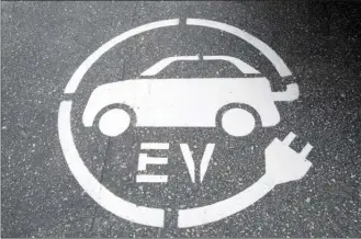  ?? Canadian Press file photo ?? An electric vehicle charging sign is pictured in Squamish, B.C. Cost and supply are the main challenges keeping Canadians from buying more electric vehicles, a survey of car sales reps suggests.