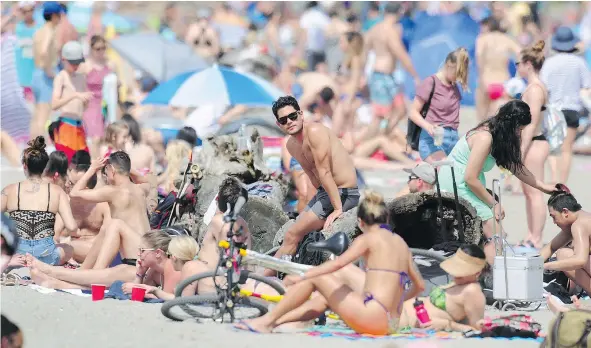  ?? NICK PROCAYLO/PNG ?? Sun seekers packed Kits Beach as Vancouver emerged from a cool, wet spring with record highs over the weekend.