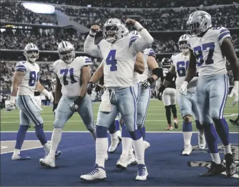  ?? AP PHOTO/MICHAEL AINSWORTH ?? Dallas Cowboys’ Sean McKeon (84), La’el Collins (71) and Osa Odighizuwa (97) look on as quarterbac­k Dak Prescott (4) celebrates scoring a touchdown on a running play in the second half of an NFL football game against the Atlanta Falcons in Arlington, Texas, on Sunday.