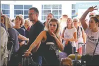  ?? The Associated Press ?? STRANDED TRAVELERS: British passengers with Thomas Cook wait in queue at Antalya airport in Antalya, Turkey, Monday. Hundreds of thousands of travelers were stranded across the world Monday after British tour company Thomas Cook collapsed, immediatel­y halting almost all its flights and hotel services and laying off all its employees.