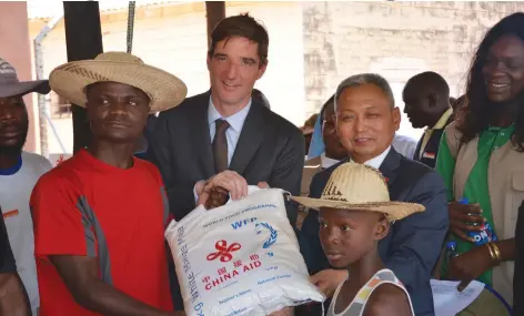  ??  ?? Mr Niels Balzer, the deputy country director for World Food Programme (with neck-tie) and Mr Chen Ning, Economics and Commercial Counsellor at the Chinese Embassy, hand over goods to refugees at Tongogara Refugee Camp on Tuesday