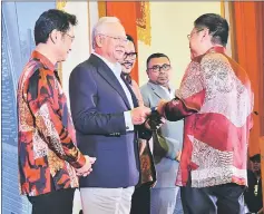  ??  ?? Najib (second left) presents a memento to an invited guest from overseas.