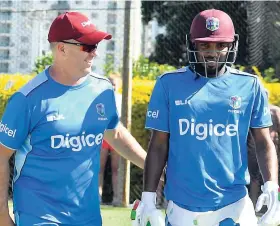  ??  ?? West Indies coach Stuart Law (left) has a word with batsman Sunil Ambris during a recent training session in preparatio­n for next month’s Test series against New Zealand.