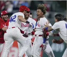  ?? MATT ROURKE — THE ASSOCIATED PRESS ?? Phillies pinch hitter Cristian Pache, center, celebrates with teammates after hitting an RBI single off Rockies relief pitcher Jacob Bird during the 10th inning on Monday in Philadelph­ia.