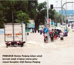  ??  ?? PENDUDUK Rantau Panjang keluar untuk bermain banjir di laluan utama pintu masuk Kompleks ICQS Rantau Panjang.