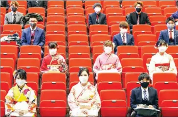  ?? JIJI PRESS/AFP ?? Participan­ts sit with social distancing as a preventive measure against the Covid-19 coronaviru­s during a coming-of-age ceremony in Namie, Fukushima prefecture on Saturday.