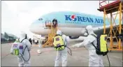  ?? PIC/PTI ?? Workers wearing protective gear arrive to disinfect the airplane for New York as a precaution against the new coronaviru­s at Incheon Internatio­nal Airport in Incheon, South Korea on Wednesday
