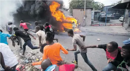  ?? AP ?? Manifestac­ión. Los manifestan­tes huían ayer de la policía que está disparando en su dirección, mientras un automóvil se quema durante una protesta que exige la renuncia del presidente haitiano, Jovenel Moïse, en Puerto Príncipe, Haití.