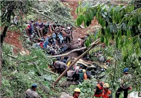  ?? AP ?? Rescuers remove the wreckages of vehicles damaged in an earthquake­triggered landslide in Cianjur.